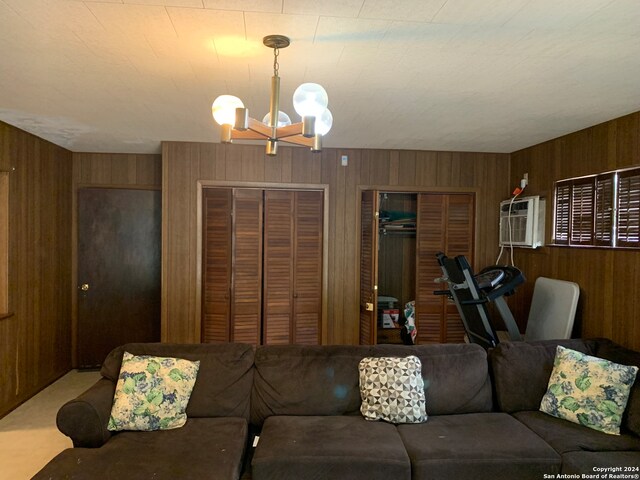 living room with wood walls and an inviting chandelier