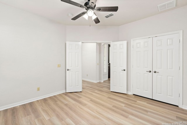 unfurnished bedroom with a closet, baseboards, visible vents, and light wood finished floors