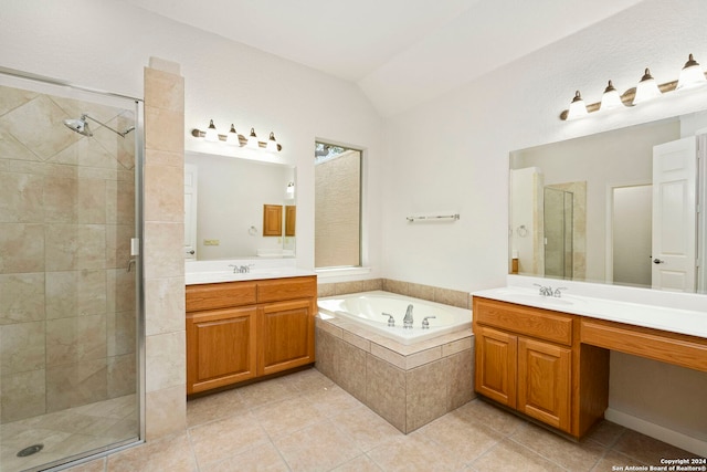 bathroom featuring a garden tub, a sink, vaulted ceiling, tile patterned floors, and a stall shower