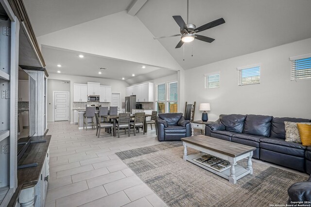 living room featuring high vaulted ceiling, beam ceiling, and ceiling fan