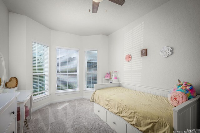 bedroom with ceiling fan, carpet, and a textured ceiling