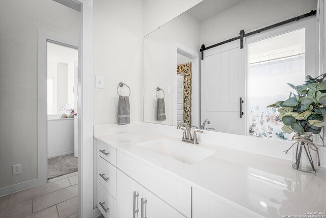 bathroom featuring vanity, a healthy amount of sunlight, and tile patterned floors