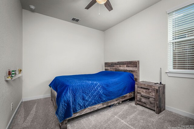 bedroom featuring carpet flooring, ceiling fan, and a fireplace