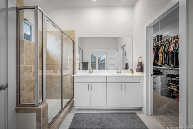 bathroom featuring tile patterned floors, an enclosed shower, and vanity