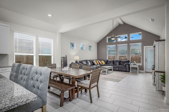 tiled dining room featuring ceiling fan and vaulted ceiling with beams