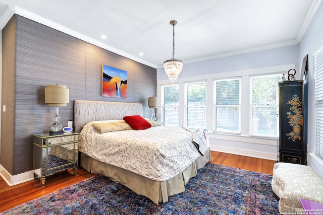 bedroom with an inviting chandelier, ornamental molding, and dark hardwood / wood-style flooring