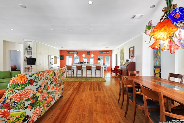 dining space with crown molding and hardwood / wood-style floors