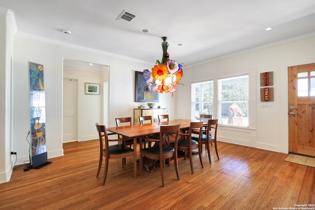 dining space with crown molding and hardwood / wood-style flooring