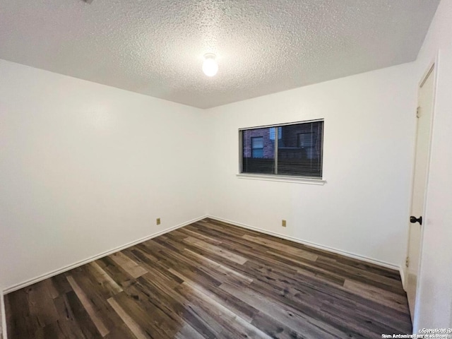 unfurnished room featuring baseboards, a textured ceiling, and dark wood-style flooring