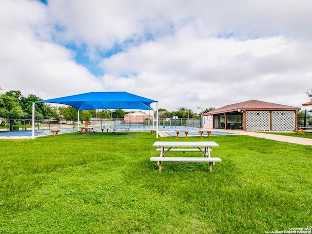 view of property's community with fence and a lawn