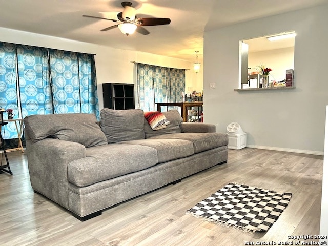 living room featuring wood-type flooring and ceiling fan