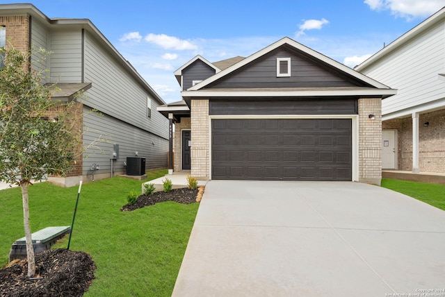 view of front facade with a front yard, driveway, central AC, a garage, and brick siding