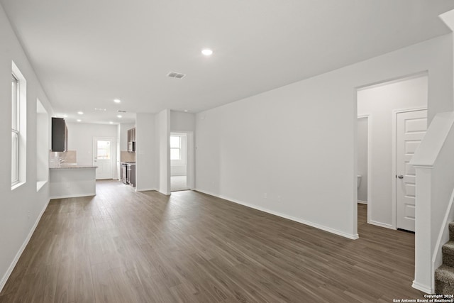 unfurnished living room featuring visible vents, dark wood finished floors, recessed lighting, stairway, and baseboards