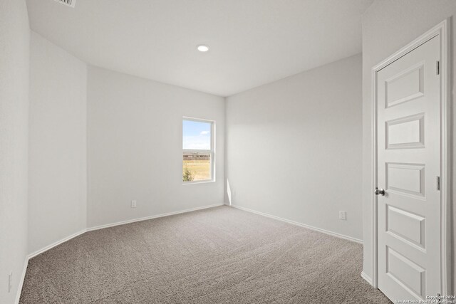 carpeted empty room with a textured ceiling