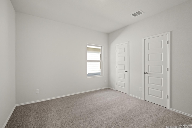 unfurnished bedroom featuring visible vents, baseboards, and carpet