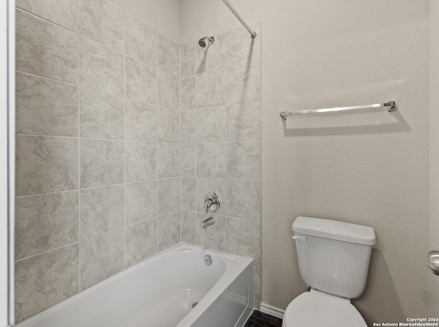 bathroom featuring toilet and tiled shower / bath