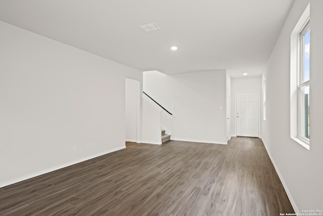 unfurnished room featuring stairway, baseboards, visible vents, recessed lighting, and dark wood-type flooring