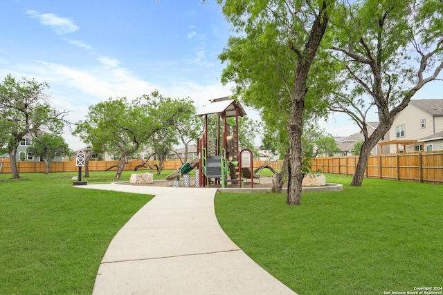 surrounding community featuring a playground, a yard, and fence