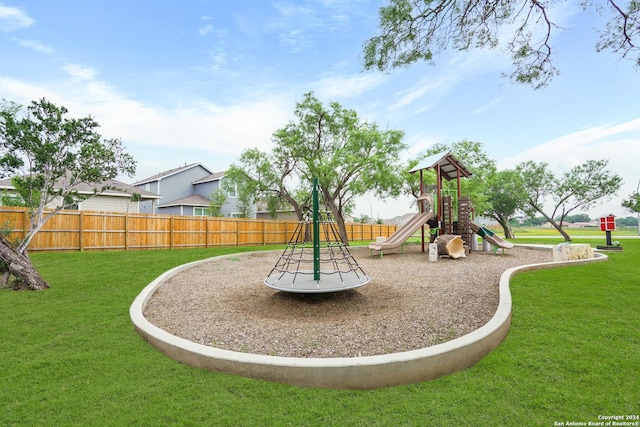 community playground featuring a lawn and fence