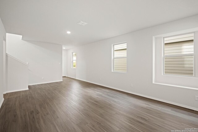 unfurnished room with a textured ceiling and dark wood-type flooring