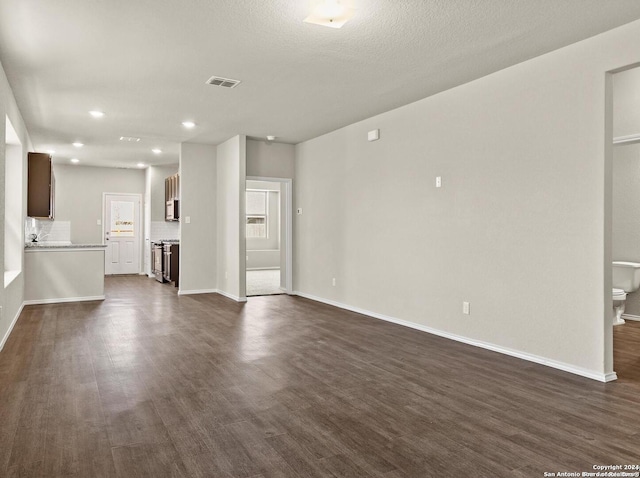 unfurnished living room featuring dark hardwood / wood-style flooring and a textured ceiling