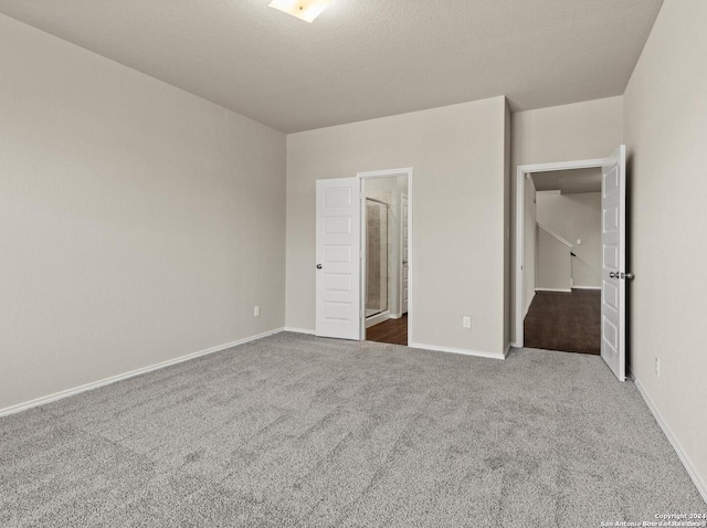 unfurnished bedroom featuring a textured ceiling and carpet