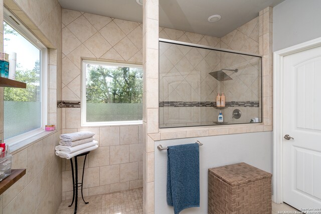 bathroom featuring tiled shower and tile walls