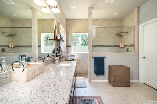 bathroom featuring tiled shower, vanity, tile walls, and tile patterned floors