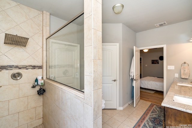 bathroom featuring a shower with door, vanity, and tile patterned floors