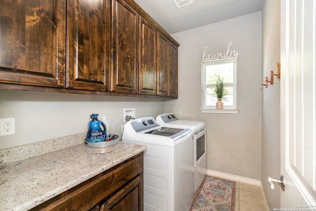 laundry room with light tile patterned floors, cabinets, and washing machine and dryer