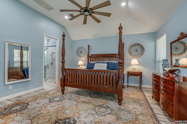 bedroom featuring ceiling fan, vaulted ceiling, connected bathroom, and light hardwood / wood-style flooring