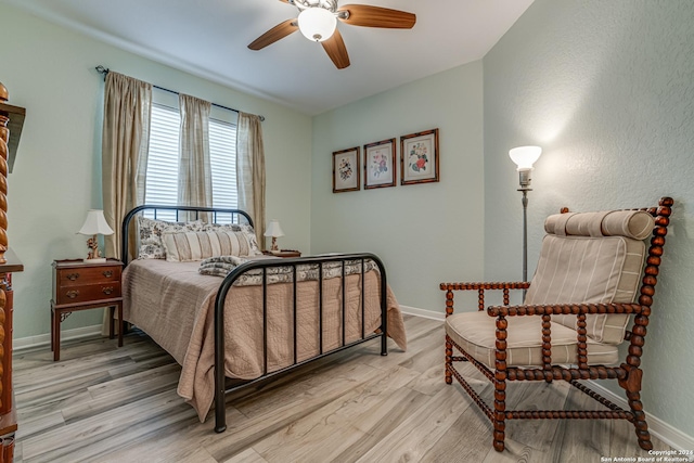 bedroom featuring a ceiling fan, baseboards, and light wood-style floors