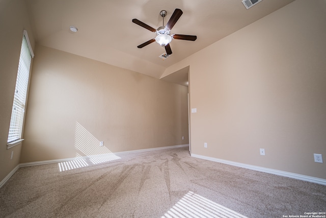 carpeted spare room featuring ceiling fan and vaulted ceiling