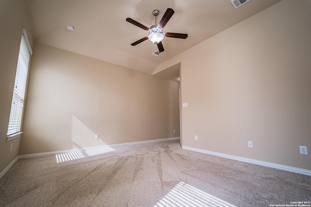 carpeted empty room featuring visible vents, baseboards, lofted ceiling, and ceiling fan