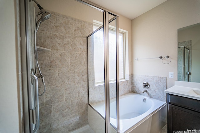 bathroom featuring a garden tub, vanity, and a shower stall