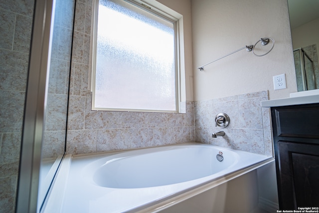 bathroom with vanity and a bath