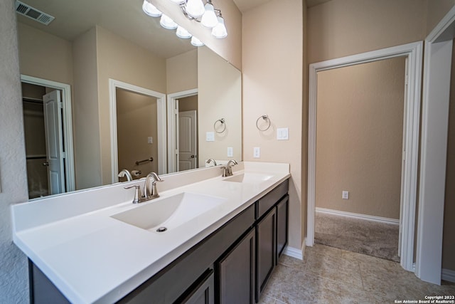full bathroom featuring a sink, visible vents, baseboards, and double vanity