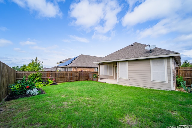 back of property with a lawn and a patio