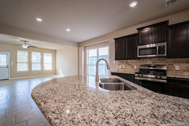kitchen featuring decorative backsplash, stainless steel appliances, visible vents, and a sink