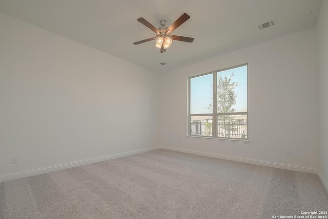 carpeted spare room featuring ceiling fan and a healthy amount of sunlight