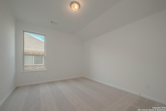 spare room with lofted ceiling and carpet floors