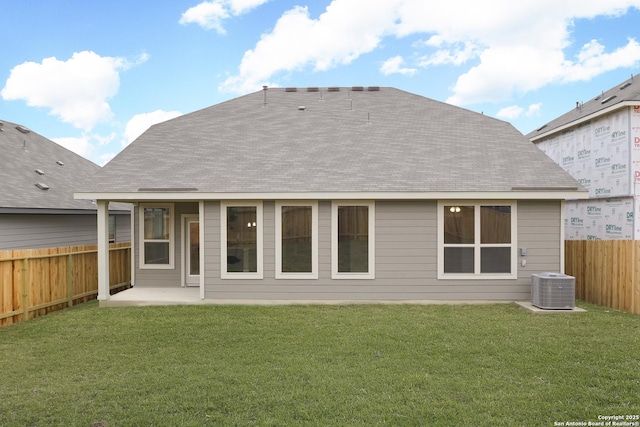 back of house with central AC unit, a patio area, and a lawn