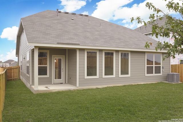 rear view of property featuring a yard, a patio, and central air condition unit