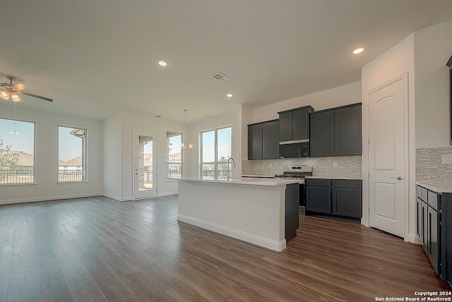 kitchen featuring tasteful backsplash, ceiling fan, a healthy amount of sunlight, and stainless steel range oven