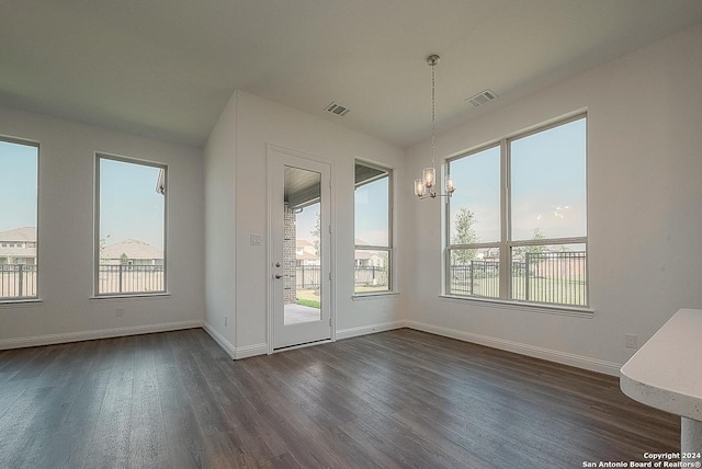 interior space featuring dark hardwood / wood-style floors, a healthy amount of sunlight, and an inviting chandelier