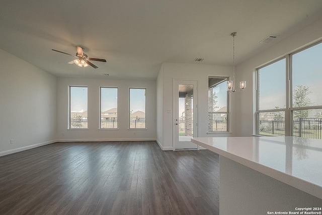 unfurnished room with dark wood-type flooring and ceiling fan with notable chandelier