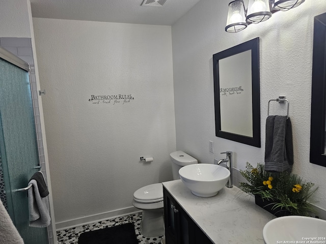 bathroom featuring tile patterned flooring, vanity, toilet, and an enclosed shower