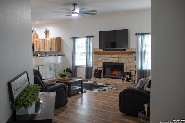 living room with ceiling fan, a fireplace, dark hardwood / wood-style flooring, and crown molding