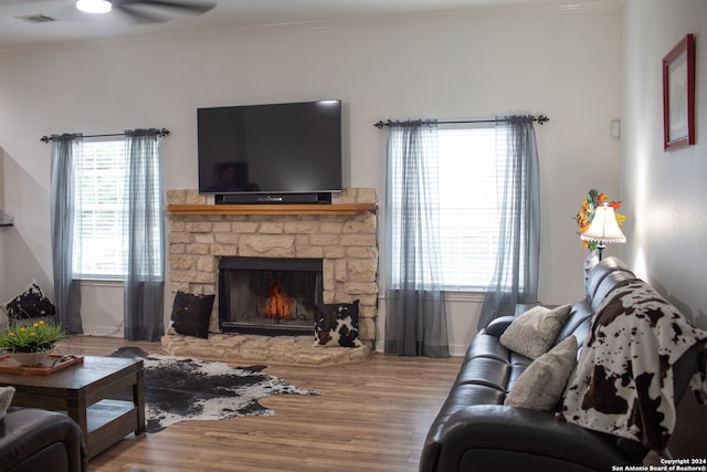 living room featuring a fireplace, crown molding, hardwood / wood-style floors, and ceiling fan