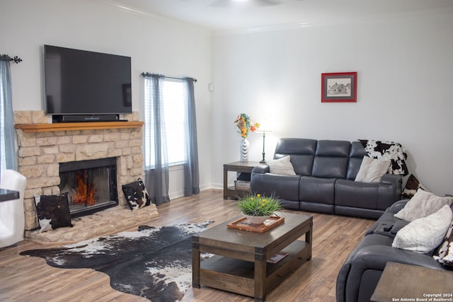 living room featuring a fireplace, ornamental molding, and hardwood / wood-style floors